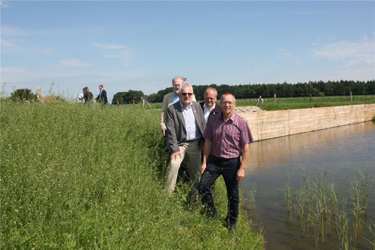 Wasser im Dorfgraben wieder sauber: Appeln darf aufatmen Saubere Sache: Ingenieur Hans Wilhelm Hammerich (Born & Ermel), Bürgermeister Ulf Voigts, Bauunternehmer Ralf Mehrtens und Ortsvorsteher Wilfried Geils stellen das Rückhaltebecken mit Bodenfilter vor. Im Hintergrund die Tauchwand aus Holz, die Schwimmstoffe zurückhalten soll.