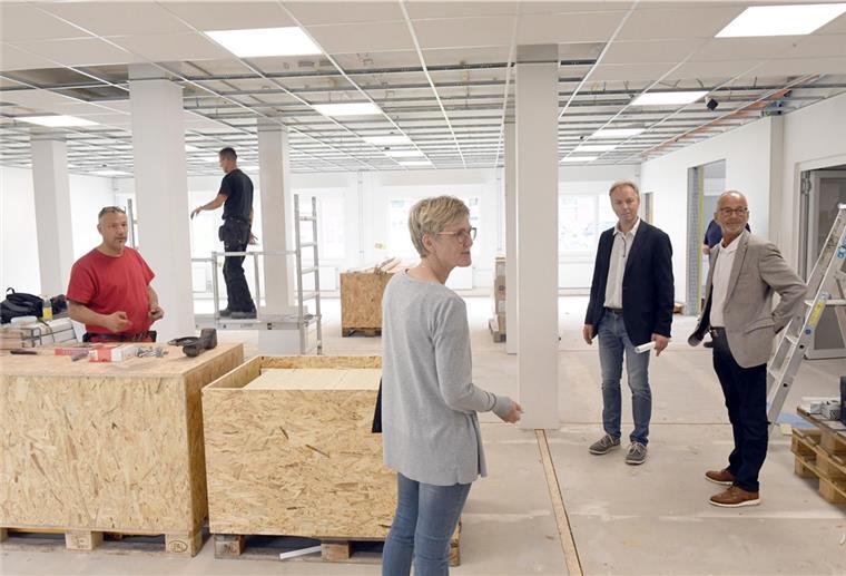 Personen stehen in der provisorischen Mensa für die Neue Grundschule.