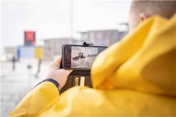 Schaulustige fotografierten am Fähranleger in Bremerhaven die Flut. Foto: Hartma...