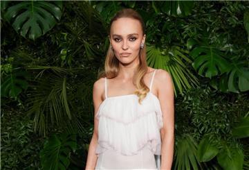 Schauspielerin Lily-Rose Depp schaut in typischer roter Teppich-Pose mit kühler Miene in die Kamera. (Archivbild)