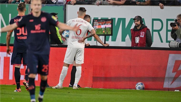 Empörte Augsburger: „Harry Kane hätte den Elfer bekommen“ Schiedsrichter Sören Storks schaut sich die Foulszene noch einmal an und nimmt den Elfmeter für Augsburg dann zurück.