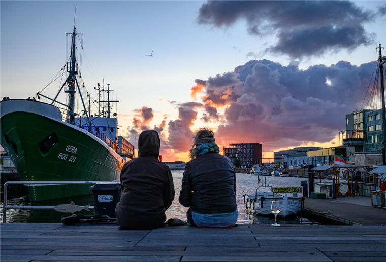 Super Sonnenuntergänge Menschen schauen am Fischereihafen auf den Sonnenuntergang.