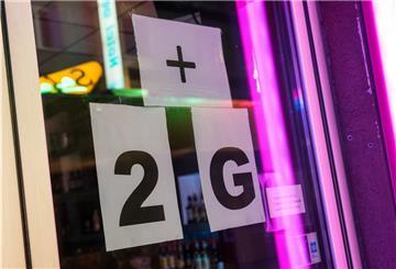 Schilder, die auf "2G-plus" hinweisen, hängen an einem Tanzlokal. Ab Freitag treten in Bremerhaven neue Corona-Regelungen in Kraft.
