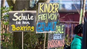 Schilder mit Anti-Gewalt-Slogans stehen bei einer Demo vor einem Schulamt.