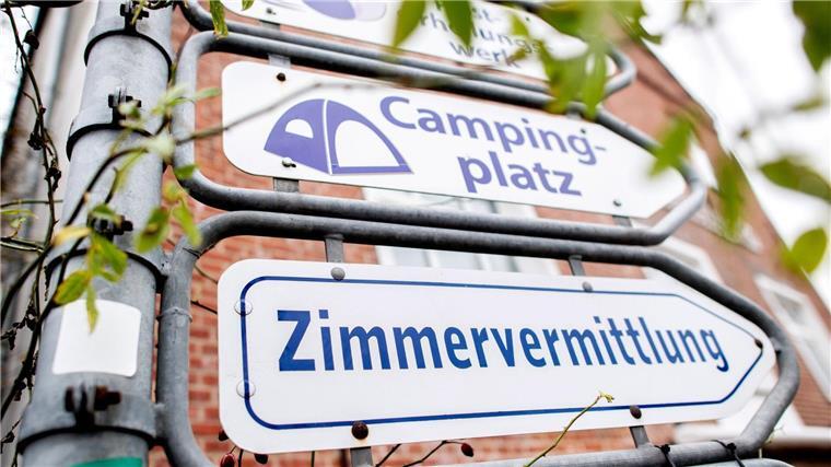 Campingplätze an Küste öffnen: Erste Dauercamper rollen an Schilder mit den Aufschriften „Campingplatz“ und „Zimmervermittlung“ hängen an einer Kreuzung.