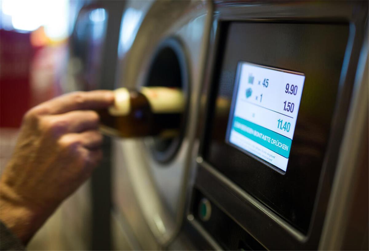 Ein Flaschensammler gibt Pfandflaschen an einem Automaten ab. Viele Supermärkte haben eine Obergrenze an Flaschen, die abgegeben werden dürfen. 