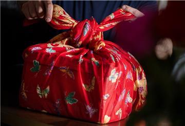 Schön und mehrfach verwendbar: Mit einem Tuch werden bei der japanischen Falttechnik Furoshiki Geschenke eingepackt.