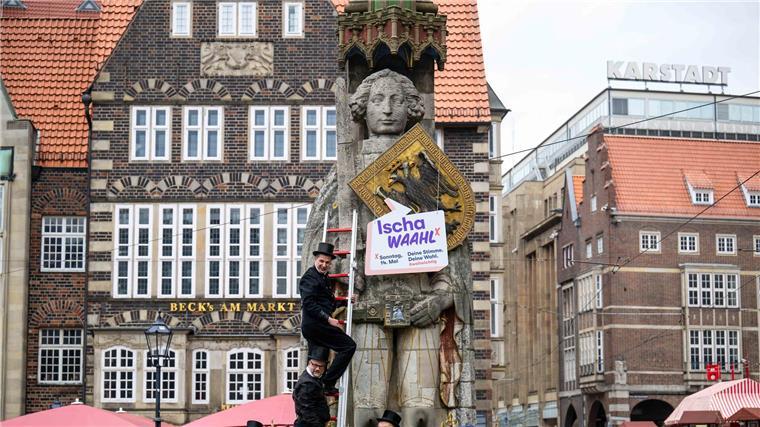 Bremer Wahrzeichen Roland wirbt für hohe Wahlbeteiligung Schornsteinfeger hängen ein Schild mit der Aufschrift „Ischa Waahl!“ an den Bremer Roland.