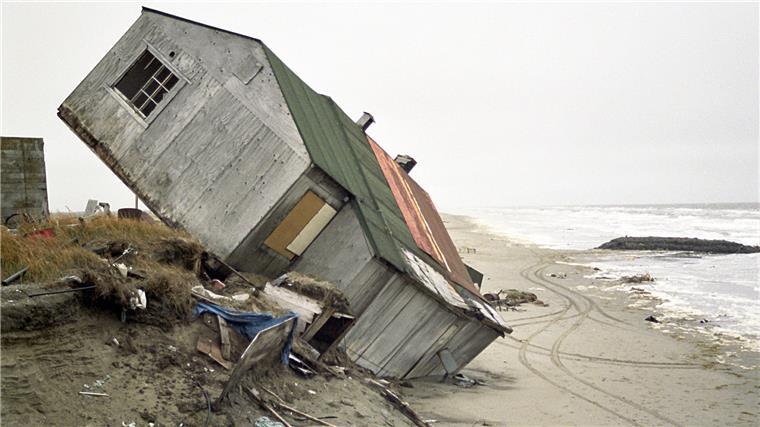 Abgestürztes Haus an aufgetauter Küste in Alaska