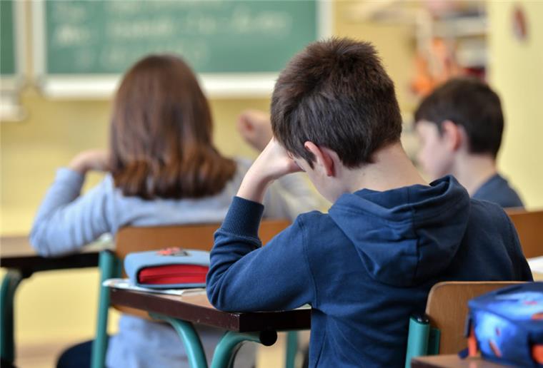 Schüler einer dritten Klasse einer Grundschule sitzen im Unterricht.