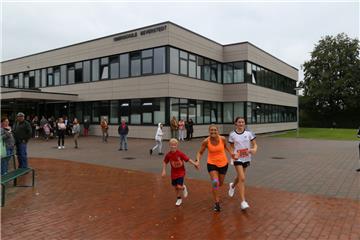 Schüler Joris, Lehrerin Alexandra Schröder und Schülerin Annika (von links) unterbrechen kurz den Spendenlauf für ein Foto vor der runderneuerten
Oberschule. Die drei laufen für das Projekt „Bewegte Pause“. 