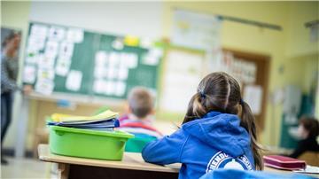 Schülerinnen und Schüler einer Grundschule sitzen mit Abstand in ihrem Klassenraum.