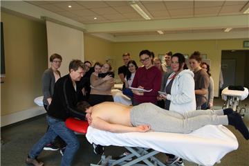 Schulleiterin Susann Agthe (links) zeigt Anja Rock (roter Kapuzenpullover)  und Wiebke Schüler (rechts davon) sowie den anderen Physiotherapie-Schülerinnen und -Schülern die richtigen Handgriffe.Foto: Gehrke
