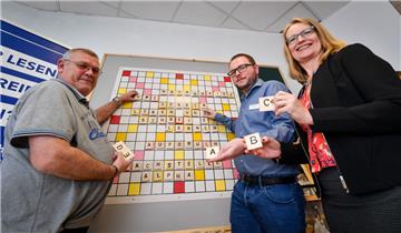 Scrabble in groß: Eike Bürkner von der Bremerhavener Fachstelle für Alphabetisierung und Manuela von Müller vom Projekt „Aufbruch - besser lesen und schreiben“. Die Veranstalter haben Uwe Boldt aus Lüneburg eingeladen, weil er dazu steht und offen darüber spricht, dass er nicht richtig lesen und schreiben kann. 