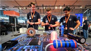 Sean (l-r), Felice und Görkem spielen bei der IdeenExpo in der Messe Hannover am Stand von VW ein Rennen mit LED-Lampen.
