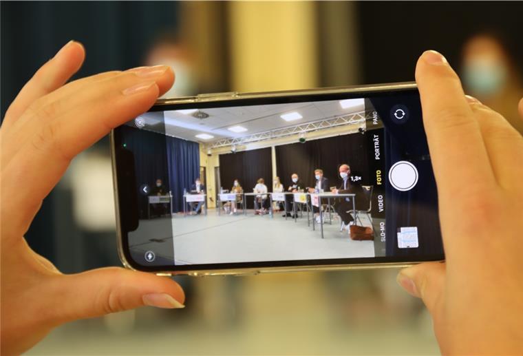 Tarmstedt: Schüler der KGS diskutieren mit Bundestagskandidaten Eine junge Frau hält ein Smartphone in der Hand.