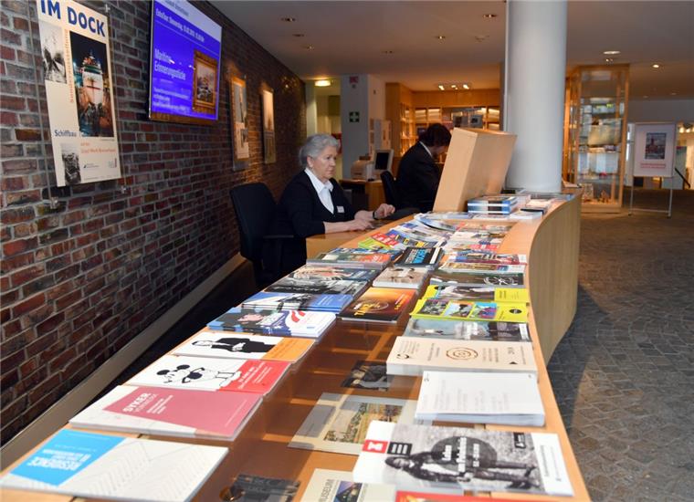 Seit 1. Januar wird im Historischen Museum in Bremerhaven kein Eintritt mehr bezahlt, die Kasse muss trotzdem besetzt sein. Pierre B. Mews ist für Eingangskontrolle, Telefon, Garderobe und Kasse (Buchverkauf) zuständig, Sigrid Schulz (vorne) muss die Überwachungskameras im Auge behalten.