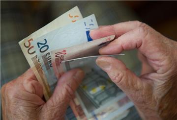 Eine Rentnerin hält Geldscheine in der Hand un zählt sie.