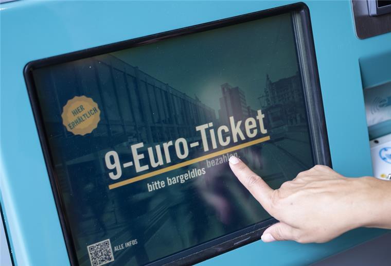 Eine Frau zieht sich an einem Fahrschein-Automaten ein 9-Euro-Ticket.