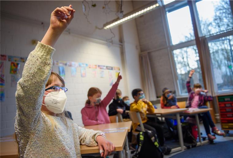 Niedersachsen: Gericht bestätigt Maskenpflicht an allen Schulen Eine Schülerin einer 4. Klasse hebt im Unterricht mit Maske die Hand.