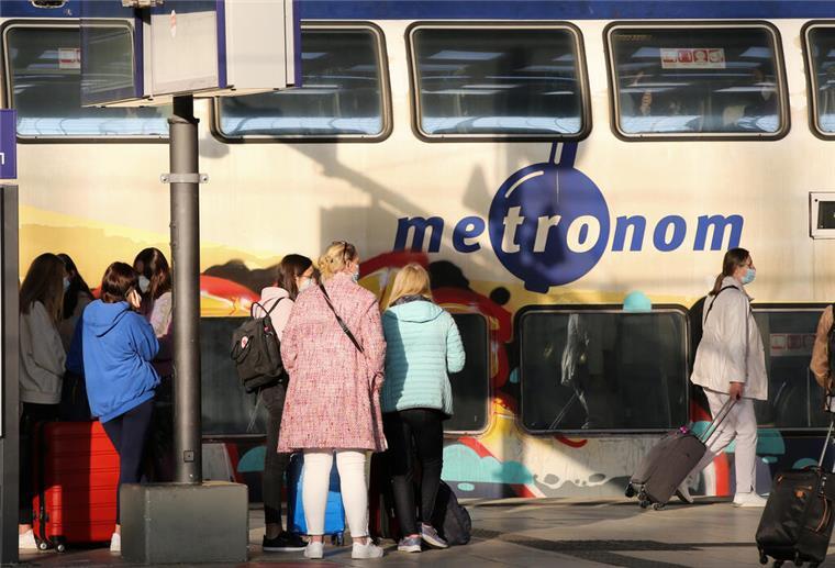 Reisende stehen vor einem Metronom 