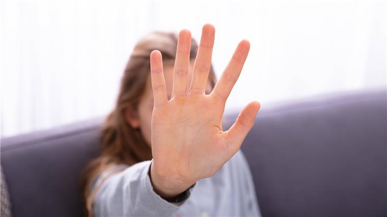 Missbrauch im Breitensport - welche Sportler gefährdet sind Ein Kind hebt abwehrend die Hand