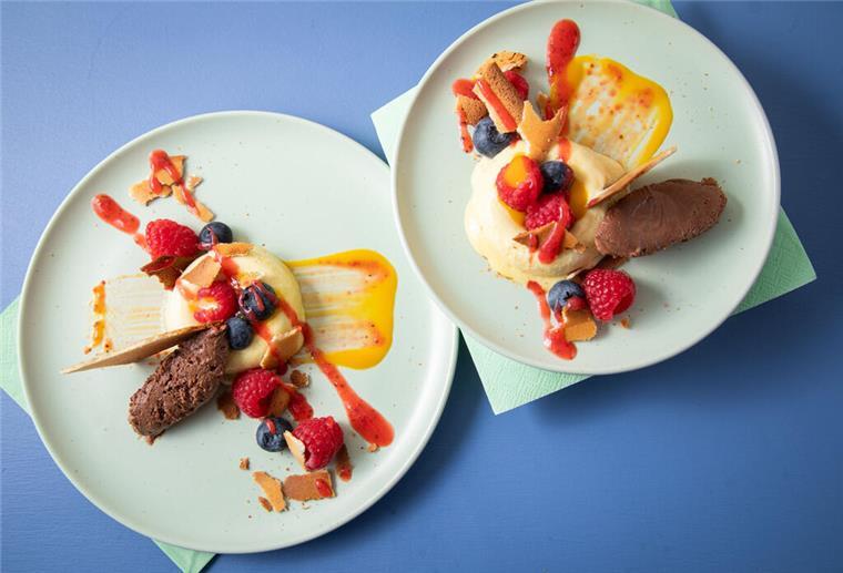Sieht aus wie ein Bagel aus Eis: In sogenannte Savarin-Formen wird das Mangoeis gefüllt und gefroren. Die Mitte wird mit Fruchtigem gefüllt, dazu einen Klecks Schokoladenmousse, Mango- und Erdbeerpüree drunter und drüber streichen.