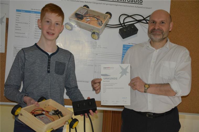 Jugend forscht: Erfolg für NIG-Schüler Simon Brandt aus der Klasse 10c hat ein elektrisch angetriebenes Fahrzeug entwickelt, für das er beim Regionalentscheid von "Jugend forscht" mit dem 2. Platz im Fachbereich Technik belohnt wurde. Lehrer Thomas Appel zeigt stolz die Urkunde. Foto Scheiter