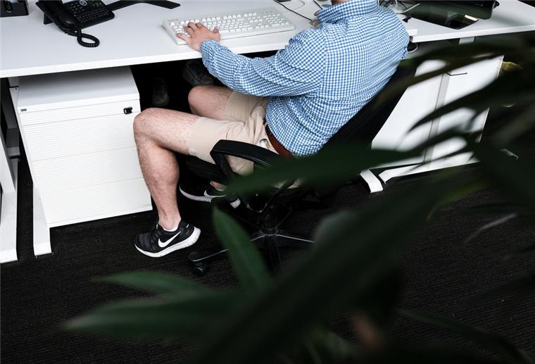 Adieu Modesünden: Sind Shorts nun kein Tabu mehr? Ein Mann sitzt mit kurzer Hose an seinem Arbeitsplatz.