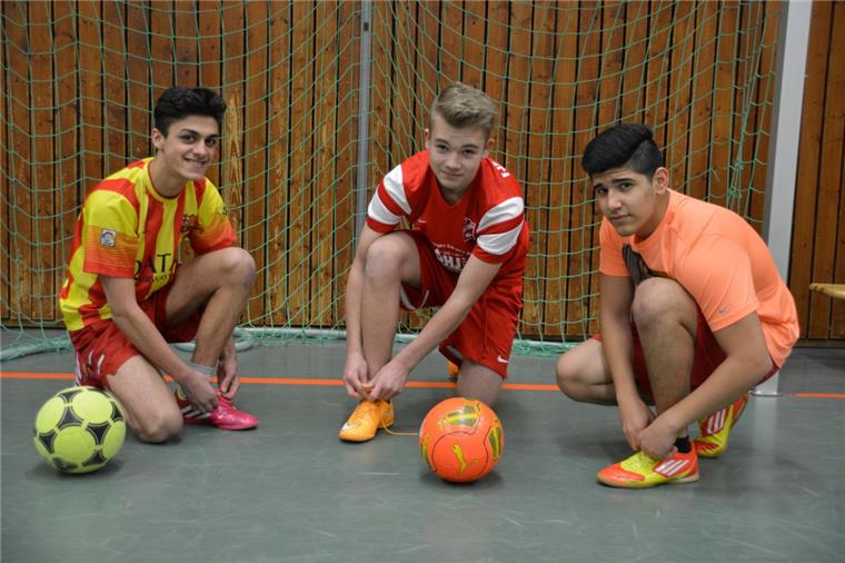 Fußball für deutsche und geflüchtete Jugendliche Sleiman Khamis (von links), Patick Bönke und Shervin Nouri schnüren vor dem Fußballturnier mit Teilnehmern aus vielen Nationen die Schuhe für den sportlich-spaßigen Wettkampf. Am Ende kickten die Jungs aus der Mannschaft Beers 1 knapp am Sieg vorbei und holten sich den zweiten Platz.