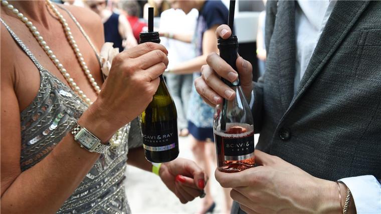 Small Talk mit Prosecco: Gäste unterhalten sich am Rande einer Modenschau in Berlin. (Archivbild)