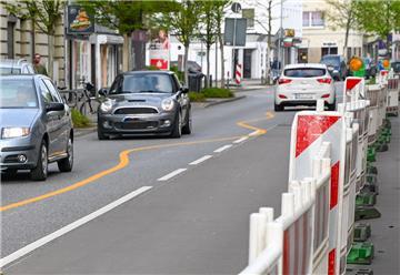 Eine Straße mit einer neu aufgeklebten Markierung, die die Autofahrer dazu zwingt, Schlangenlinien zu fahren. 