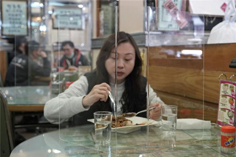 So kann ein Restaurantbesuch zurzeit in Hongkong aussehen: Eine Kundin sitzt hinter einer Plexiglaswand beim Mittagessen. Die Angst vor einer Verbreitung des Virus macht Restaurants in Asien erfinderisch.  