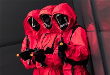 Mitarbeiter des Kostümhändlers Deiters posieren in Kostümen aus der Serie "Squid Game" des Streaming-Anbieters Netflix.