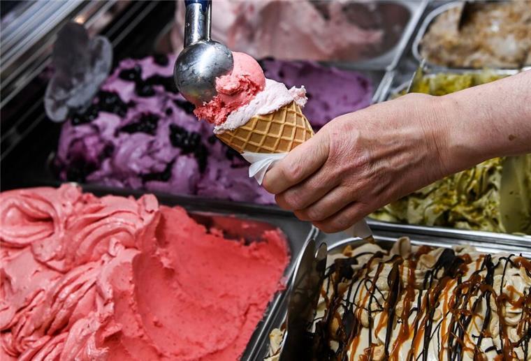 Teures Eis, billige Tricks? So erkennt man echte Qualität in der Eisdiele Eine Kugel Erdbeereis wird in einer Eisdiele auf eine weitere Kugel in einem Waffelhörnchen gesetzt.