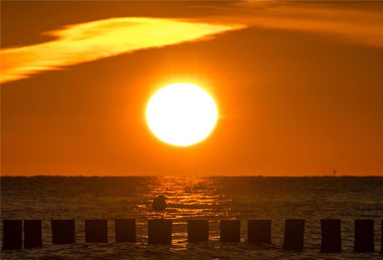 Sonne satt und Tropennacht-Gefahr – jetzt rollt die Hitzewelle an Sonne am Meer, Sonnenuntergang. Sonne, blauer Himmel und steigende Temperaturen: In Niedersachsen und im Land Bremen kündigt sich ein heißer Dienstag an – besonders im Landesinneren wird es sommerlich warm.