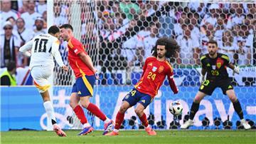 Spaniens Marc Cucurella (M) bekommt den Schuss von Deutschlands Jamal Musiala an den Arm.