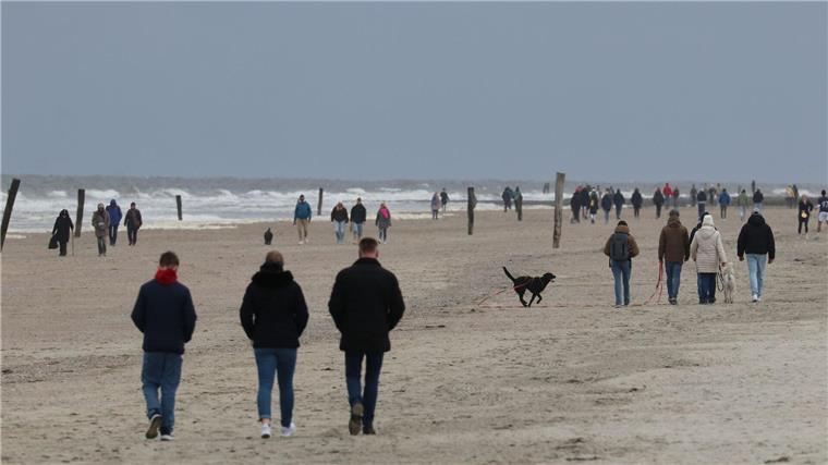 Urlauber entspannen an Ostertagen auf Norderney Spaziergänger am Strand der ostfriesischen Insel Norderney.