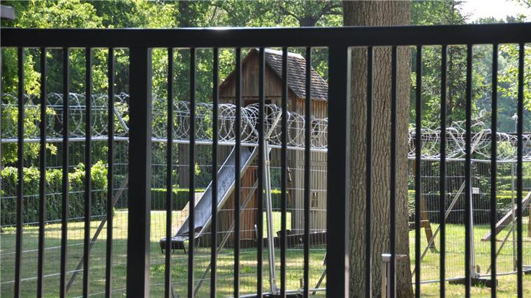 Ein Spielplatz hinter Stacheldraht.