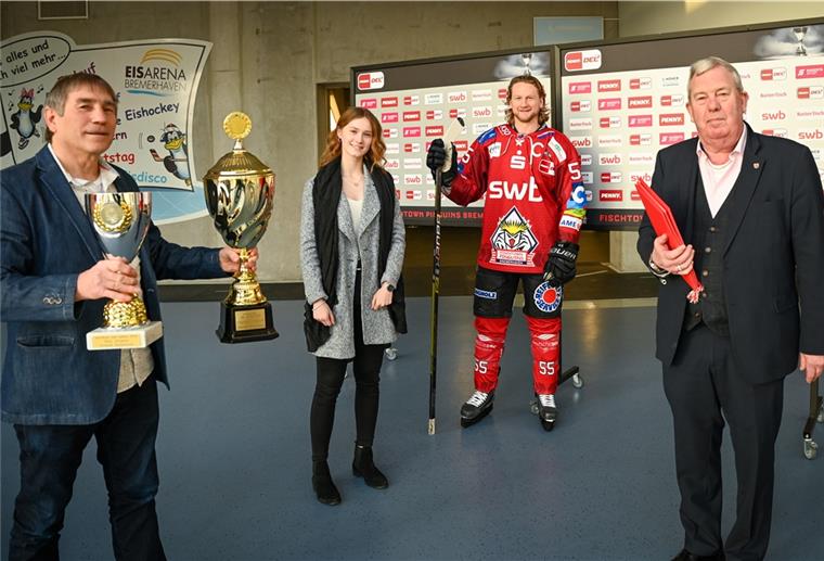 Sportstadtrat Paul Bödecker (rechts) und Jens Ennen (links) vom Magistrat ehren Rike Jürgens und die Fischtown Pinuins - hier Kapitän Mike Moore - als Sportler des Jahres 2019.