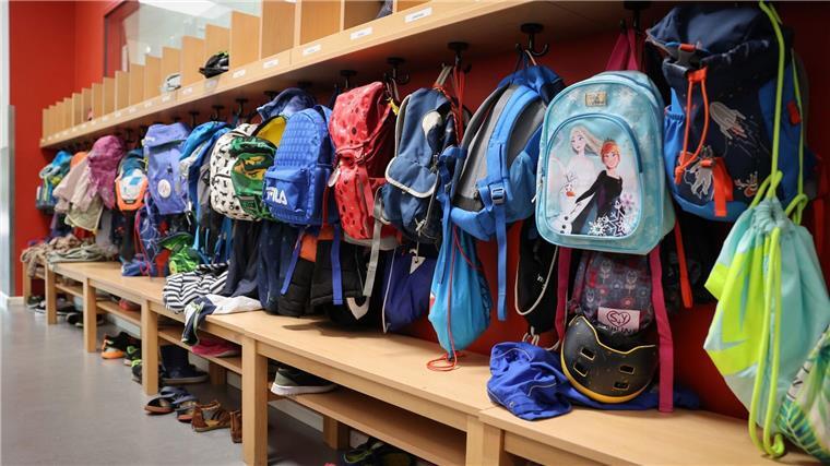 Millionenförderung für Vorschulkinder mit Sprachproblemen Sporttaschen und Schulranzen hängen an der Garderobe vor einem Klassenzimmer.