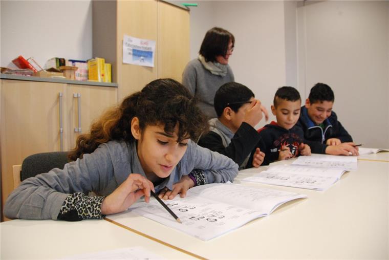 Sprache als Basis (von links): Zainab (12), Mustafa (10), Mohamad (9) und Lewin (15) lernen mit der pensionierten Lehrerin Veronika Nass.  Foto Fixy 
