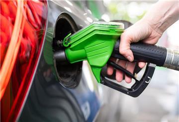 Eine Frau hält an einer Tankstelle an einer Zapfsäule eine Zapfpistole in der Hand und betankt ein Auto. Der Spritpreis im Oktober ist nach einigen günstigen Monaten nun wieder gestiegen.
