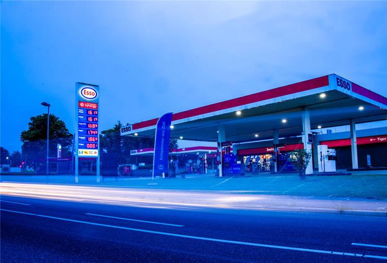 Verpasst? Diese Uhrzeit ist jetzt die günstigste zum Tanken Auto fahren am Morgen an einer Tankstelle vorbei an deren Preistafel die aktuellen Literpreise für Kraftstoff angezeigt werden.