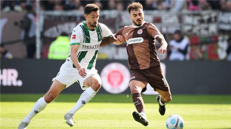 „Von allem zu wenig“: Gladbach hadert nach Remis bei Pauli St. Paulis Danel Sinani (r) und Mönchengladbachs Tim Kleindienst im Kampf um den Ball.