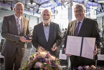 Stadtverordnetenvorsteher Torsten von Haaren (links) und Oberbürgermeister Melf Grantz überreichen die Verdienstmedaille der Stadt an Rolf Stindl (Mitte) im Fischbahnhof.