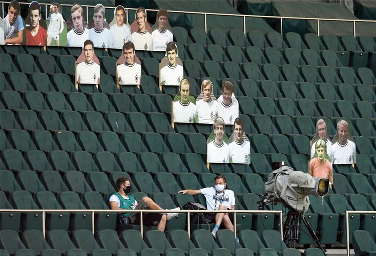 DFL drängt auf Rückkehr der Fans Statt Zuschauen sind beim Geisterspiel Borussia Mönchengladbach gegen Hertha BSC Berlin Pappfiguren mit Fotos von ehemaligen Spielern auf der Tribüne aufgestellt.