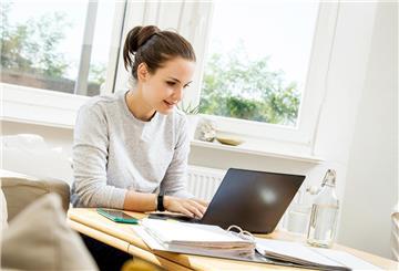 Eine Frau sitzt am Laptop.