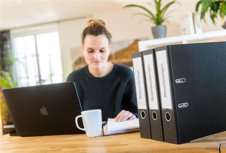 Steuererklärung 2024: Fünf wichtige Pauschalen für Steuerzahler Eine Frau sitzt am Schreibtisch vor ihrem Laptop und Ordnern