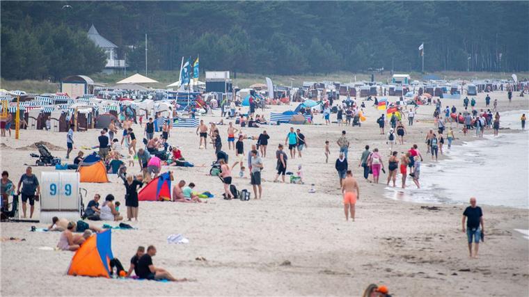 Strandbesucher genießen trotz wolkigem Himmel das Strandleben in Binz.